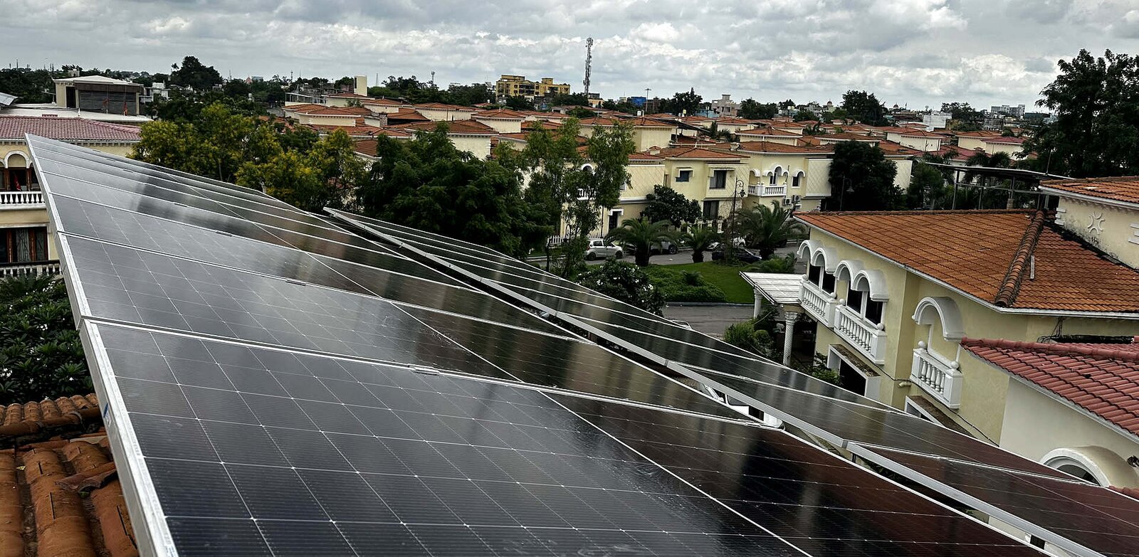 Rooftop solar panel array installed by HP Solar, overlooking the housing colony below
